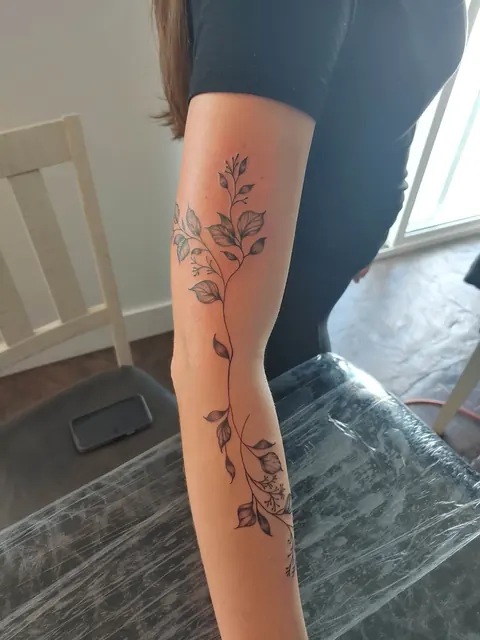 Rose vine running the length of the arm, fine line