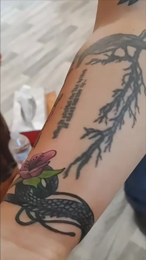 Dragon, blossoms and script down the forearm