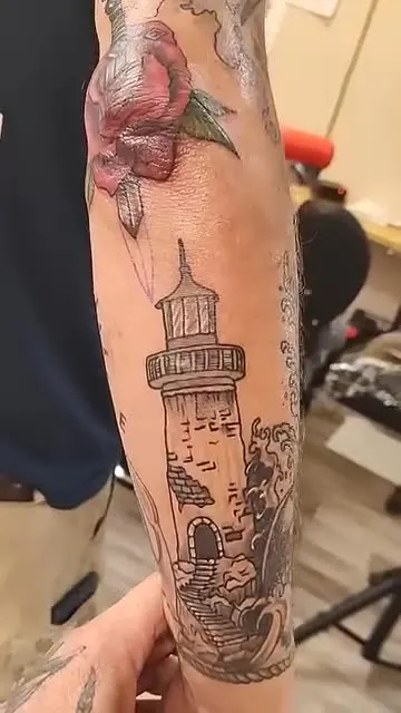 Full sleeve with a rose and dagger, a lighthouse and a compass